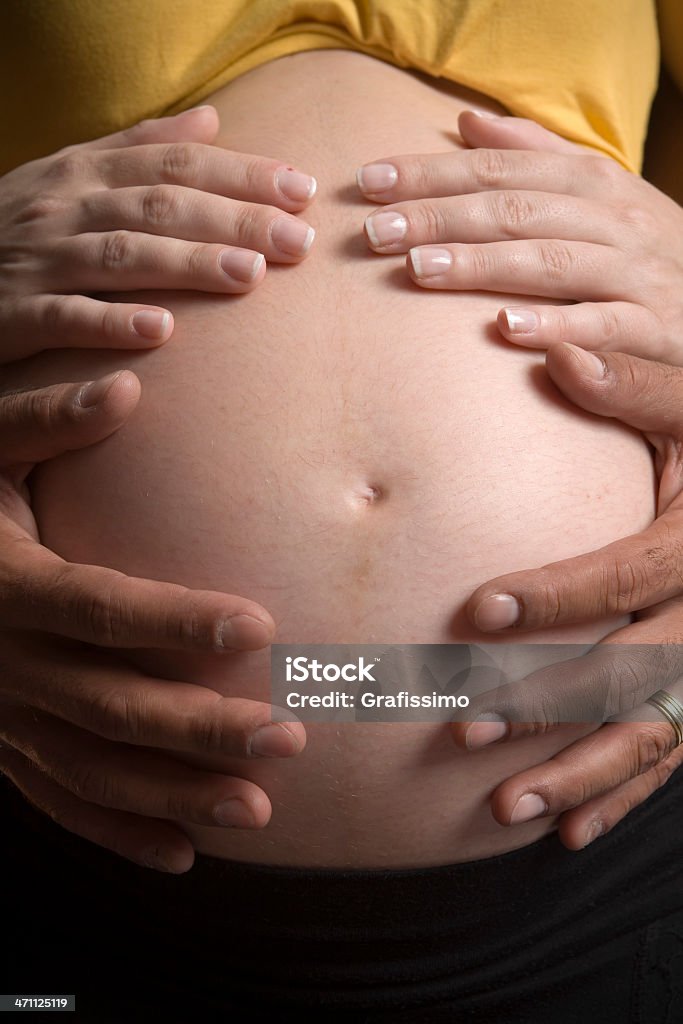 Four hands on belly of pregnant woman Adult Stock Photo