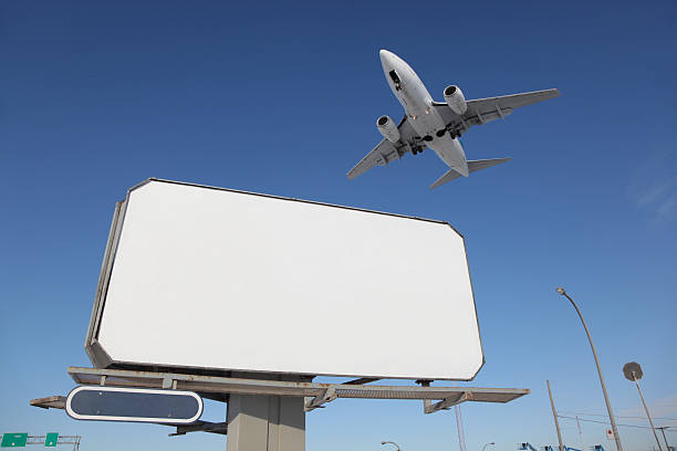 открытый реклама знак с самолет прохождение выше - copy space road sign sky above стоковые фото и изображения