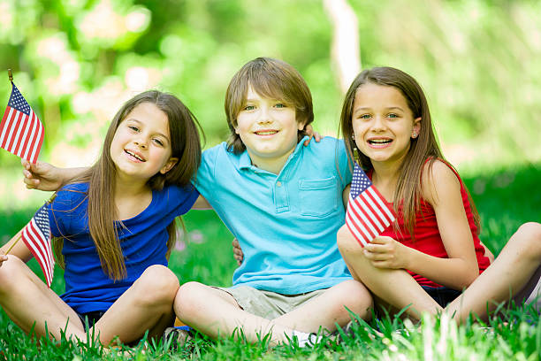 istock Children hold American flags outdoors, summer. Memorial Day, July 4th. 471129984