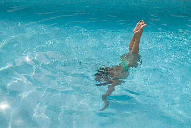istock woman diving in a swiming pool 471130375