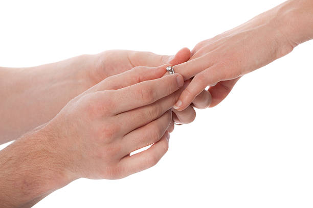 istock Man Placing Diamond Engagement Ring on Woman Hands Close Up 471132305