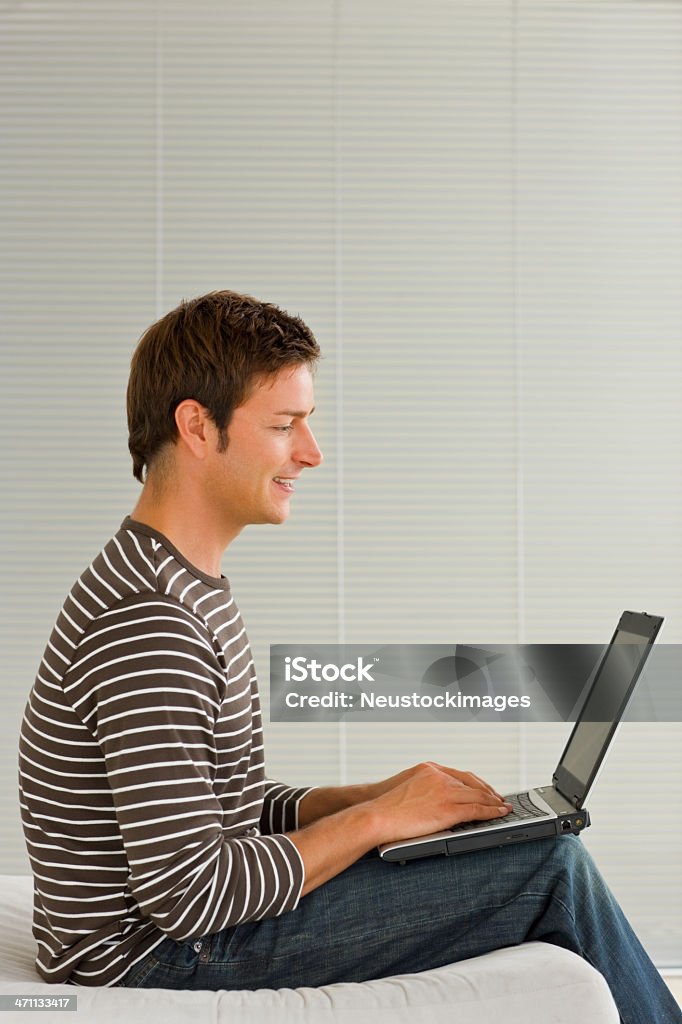 Joven usando una computadora portátil - Foto de stock de 20 a 29 años libre de derechos