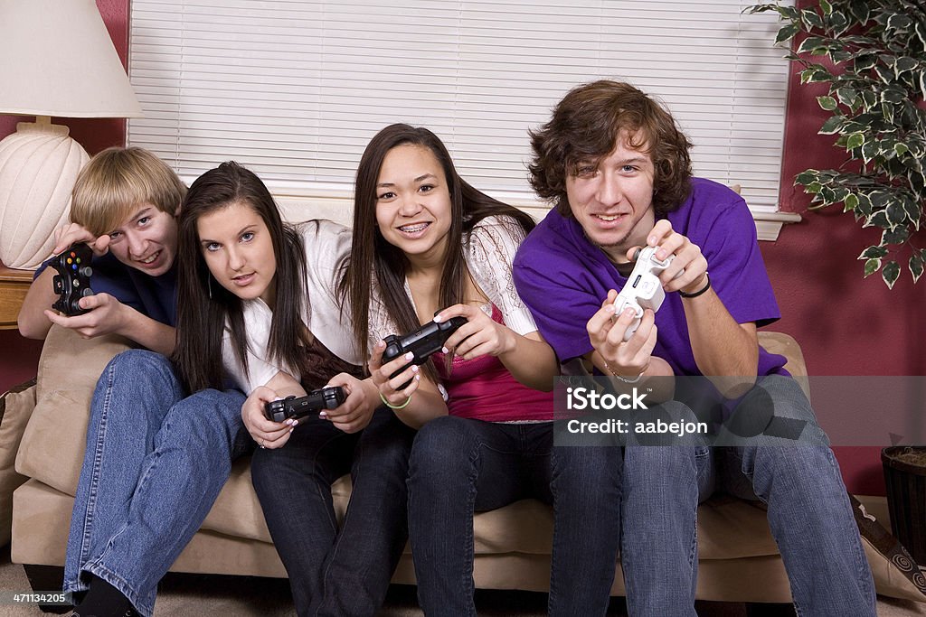 Playing 4 teens playing video games. All images from this series: Video Game Stock Photo