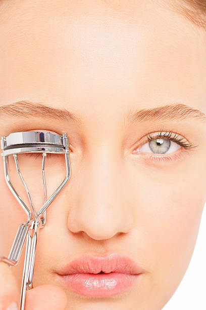 istock Young woman applying eyelash curler 471134737