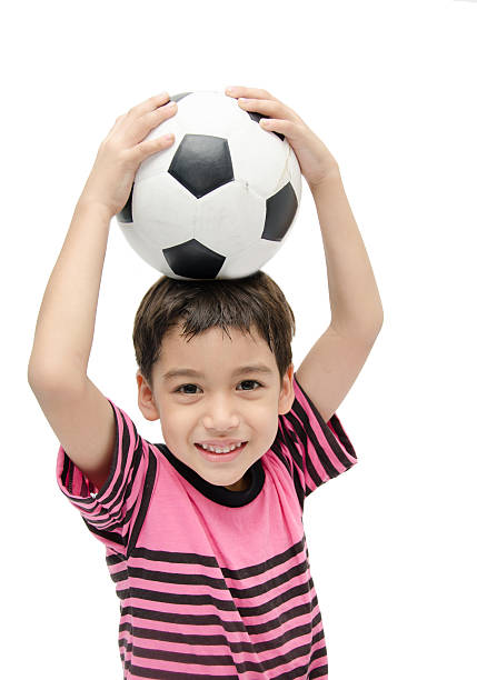 istock Little boy holding football on white background 471135268