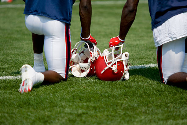 Football players watch from the sidelines as members of their team practice.Other football shots: