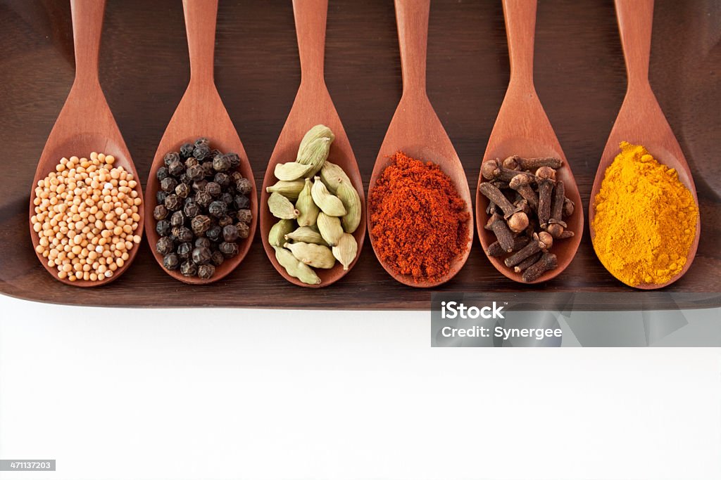 Spices on spoons A selection of spices on wooden spoons. Black Peppercorn Stock Photo