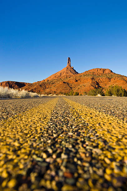 Castleton Tower and Asphalt Road Scenic Castle Valley Moab Utah Castleton Tower and Asphalt Road Scenic Castle Valley Moab Utah.  ProPhoto RGB. single yellow line sunlight usa utah stock pictures, royalty-free photos & images