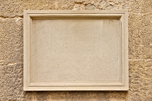 Blank stone plaque for adding your own inscription, set into a honey-coloured stone wall.