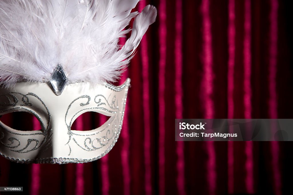 Mask White carnival mask in front of a red curtain. Arts Culture and Entertainment Stock Photo