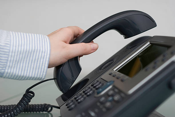 istock Making a call, woman's hand pickung up phone receiver 471140347