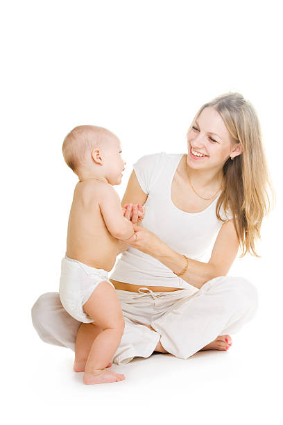 Madre e bambino prendendo i suoi primi passi - foto stock