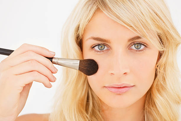 istock Young woman applying blusher on face 471141011