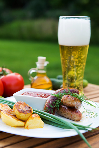 tasty grilled meat sausages  on dish and vegetable