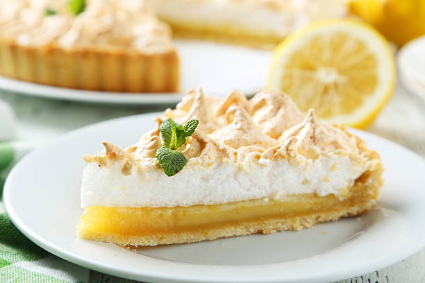 istock Lemon meringue pie on plate on white wooden background 471145052