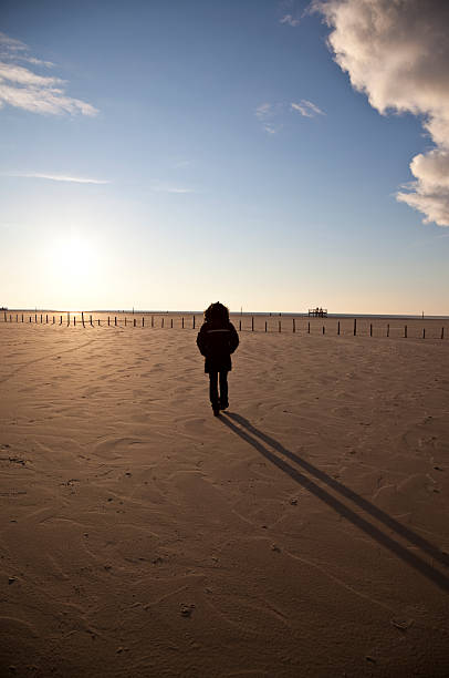 istock lonely woman walking in the sunset 471146419