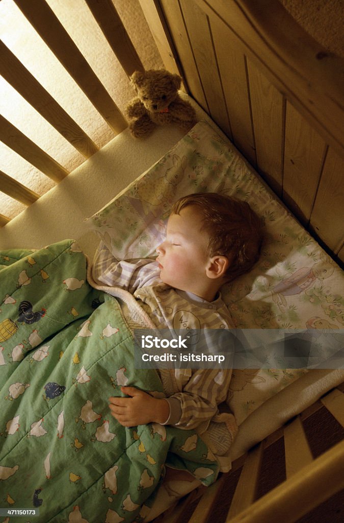 Boy sleeping A young boy sleeps in his cot Child Stock Photo