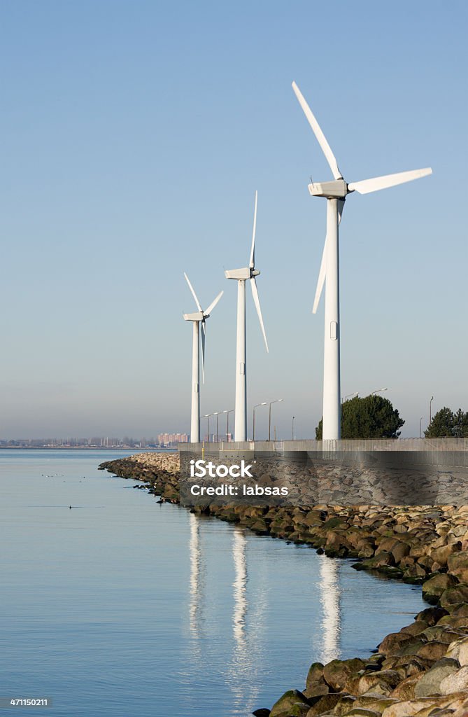 Turbine eoliche in riva al mare, il cielo azzurro. - Foto stock royalty-free di Affari finanza e industria