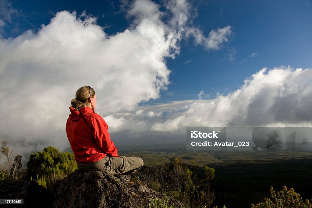 Meditation Woman in red Jacket doing Yoga and Meditate on the Mt Kilimanjaro moutain with Beautiful blue Sky, Canon EOS 5D.  Adult Stock Photo