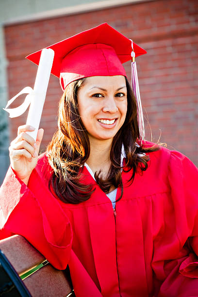 istock pretty graduate sitting on bench with diploma 471151385