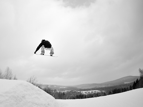 Snowboarder performs a freestyle stunt in a terrain park.