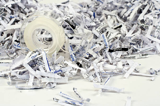 Shredded paper with focus on teeth of a tape dispenser stock photo