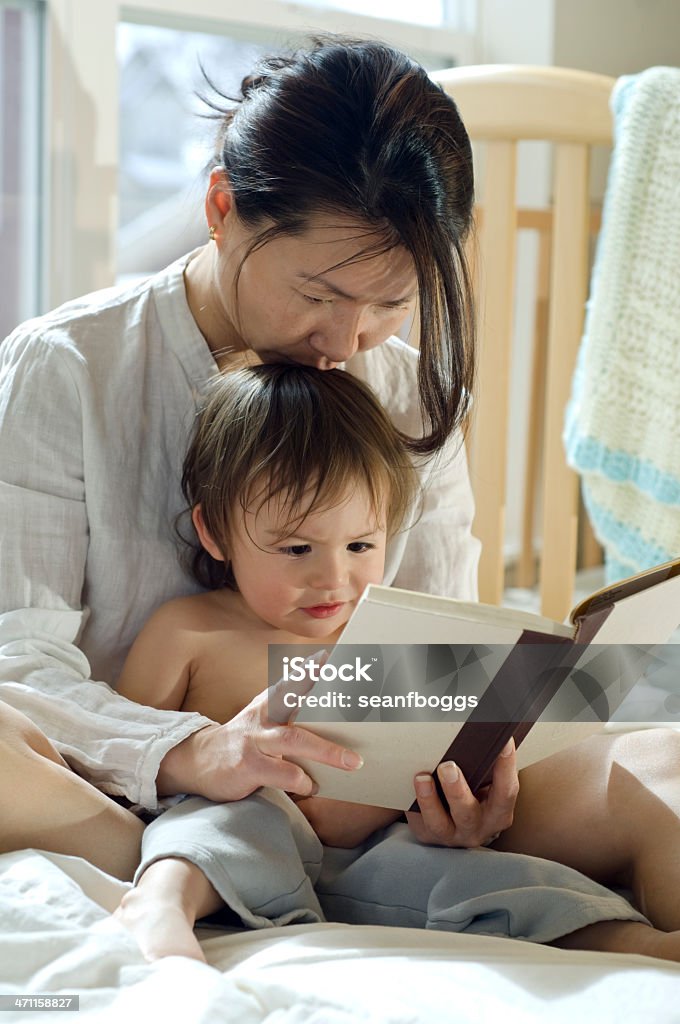 読みながら母親にキスをするストーリーを息子 - おとぎ話のロイヤリティフリーストックフォト