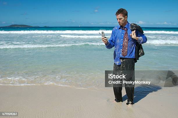 Photo libre de droit de Castaway Homme Daffaires Debout À Envoyer Des Sms Sur Le Téléphone À Clapet banque d'images et plus d'images libres de droit de Robinson