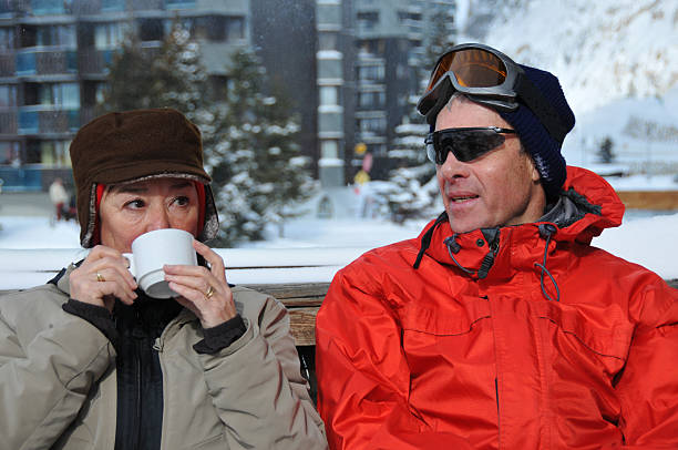 istock Senior couple drinking hot coco on ski piste 471160327