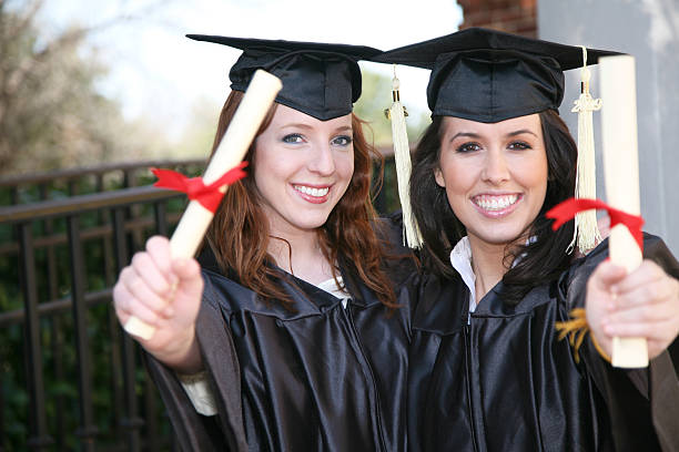 istock Graduates holding out diplomas 471161173