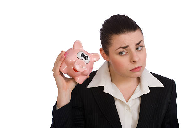 Worried young business woman with piggybank stock photo