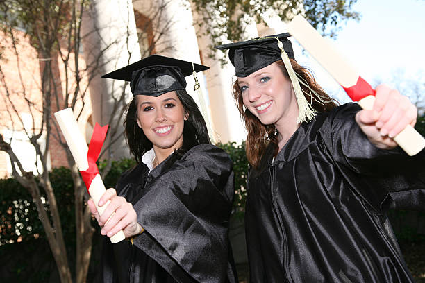 istock Two Graduates holding out diplomas 471164325