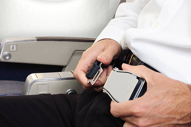 istock Person buckling an airplane seatbelt 471164715