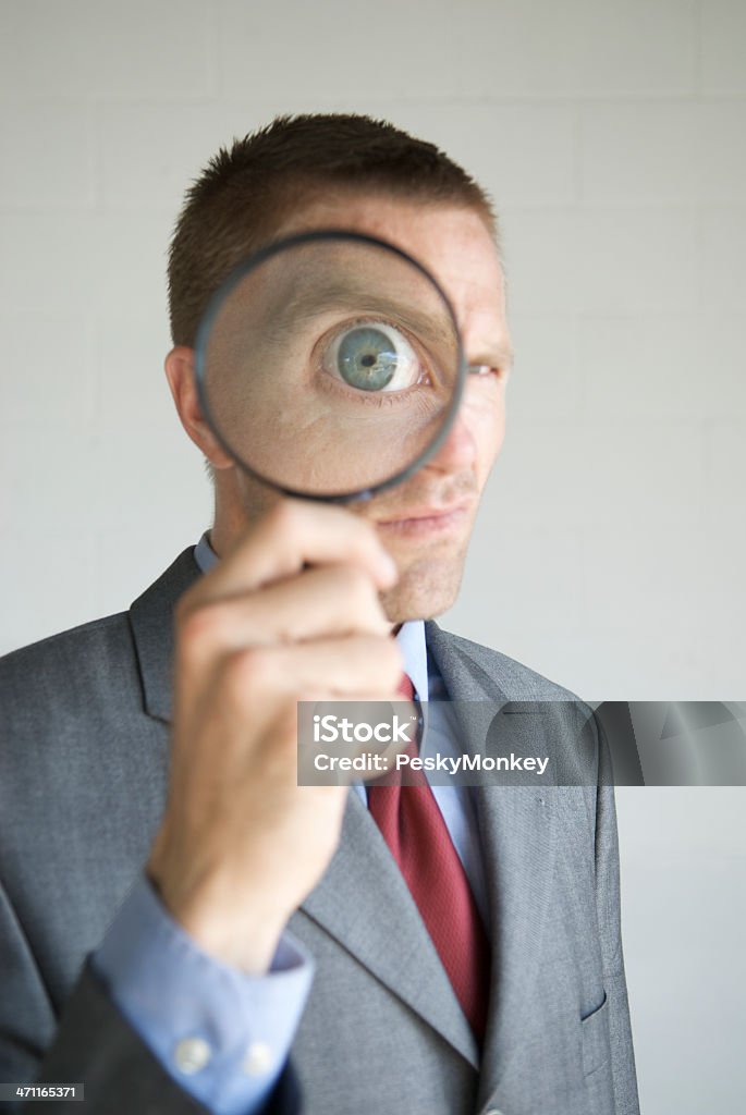 Uomo d'affari con lente di ingrandimento invadere la Privacy - Foto stock royalty-free di Lente d'ingrandimento