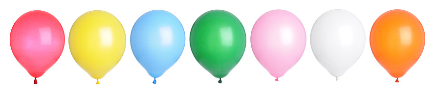 Seven brightly lit party balloons in a row on a white background.