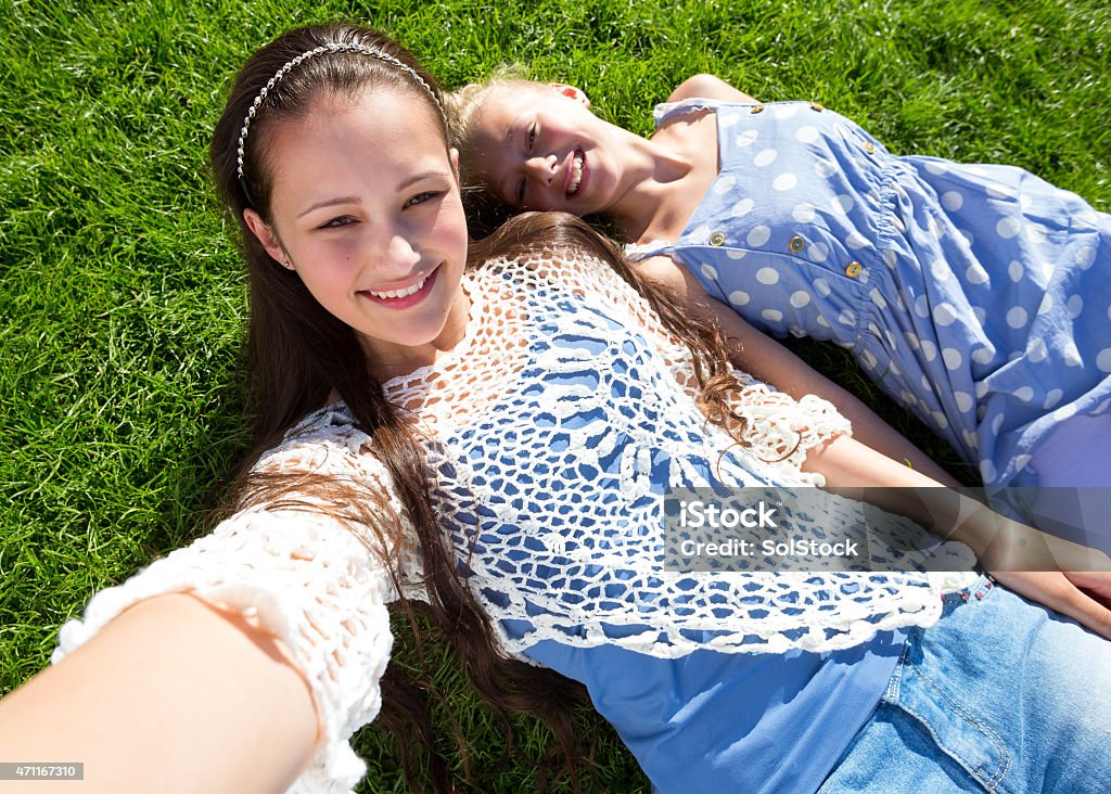 Selfie in the Sun Point of view of two teenage girls lying on the grass taking a selfie. 20-29 Years Stock Photo