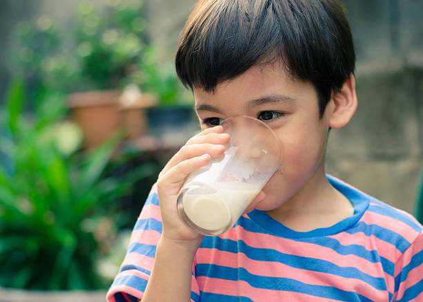 istock Littl boy drinking milk in the park vintage colo style 471169082