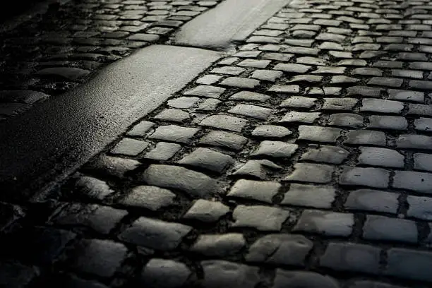 First light of the day falls on a wet cobblestone street