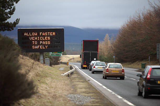 traffic advice sign cars behind lorry on a road trip, A9, Cairngorms, Scotland.  cairngorm mountains stock pictures, royalty-free photos & images