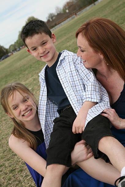 istock Mother and Daughter holding up brother 471171921