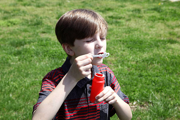 istock Little boy trying to blow bubbles 471172176