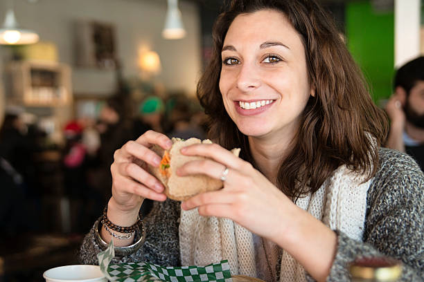 istock Young woman eating lunch at a restaurant. 471172322