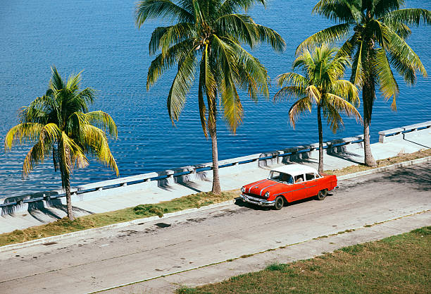 Santiago, Cuba-October 18, 2019: American classic 4 door sedan cars, green Dodge Kingsway 1956 - red Chevrolet Styleline Deluxe 1952 at the National Shrine Basilica Our Lady Charity rear side parking.