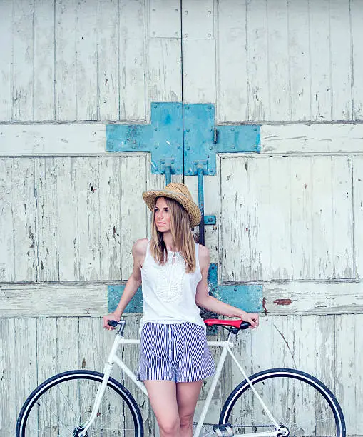 Photo of Pretty girl posing with a bicycle
