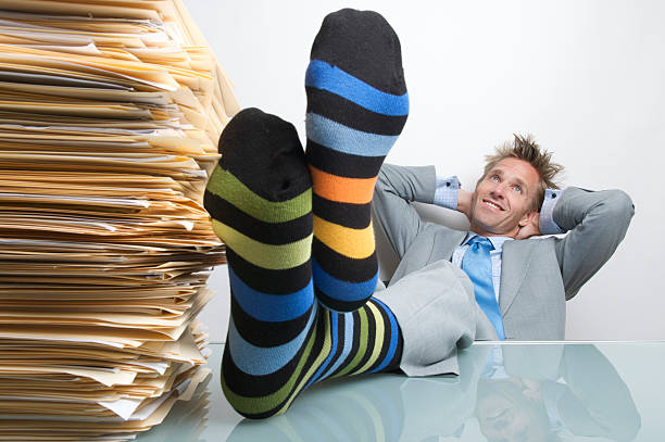 istock Businessman Office Worker Reclining at Desk Socks Up Dreaming 471172947