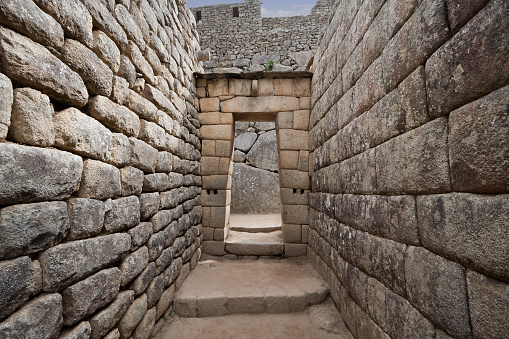 Typical construction of stone of a doorway at Machu Picchu. This precision, combined with the rounded corners of the limestone blocks, the variety of their interlocking shapes, and the way the walls lean inward, is thought to have helped the ruins survive devastating earthquakes.
