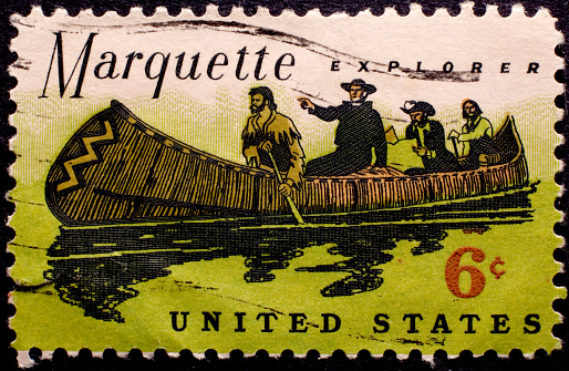 Old, canceled postage stamp featuring Marquette exploring in a canoe.