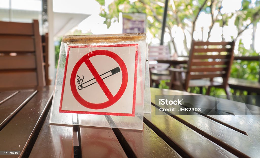 No smoking sign displayed No smoking sign displayed on the wooden table in the public cafe No Smoking Sign Stock Photo