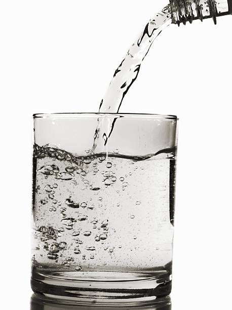 wlewając wodę do szklanki na białym tle - water bottle purified water water drink zdjęcia i obrazy z banku zdjęć
