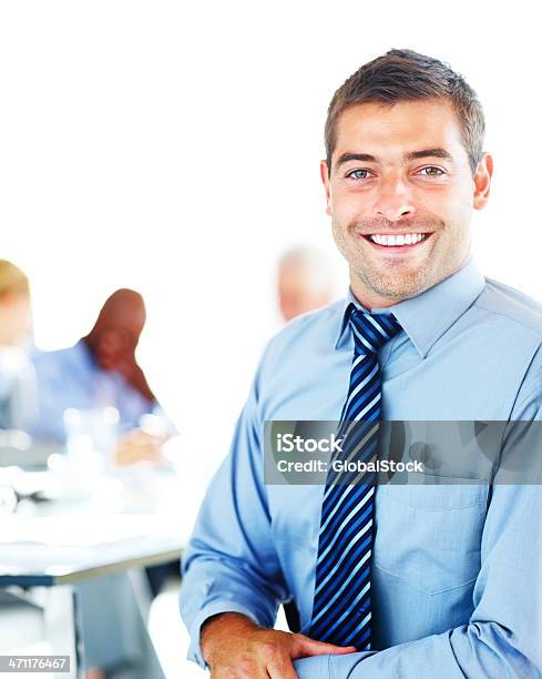 Uomo Daffari Sorridente Con I Colleghi In Background - Fotografie stock e altre immagini di Abbigliamento formale